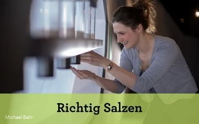 Das Schaubild eine Frau, die an einer von fünf Salzmühlen dreht. Sie hält ihre Hand unter die Mühle.