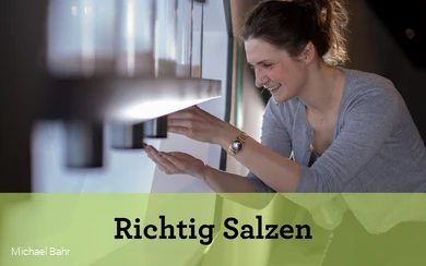 Das Schaubild eine Frau, die an einer von fünf Salzmühlen dreht. Sie hält ihre Hand unter die Mühle.